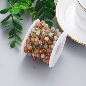 Close-up of colorful natural stone beads on a stainless steel chain for DIY jewelry