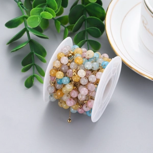 Macro shot of colorful stone beads on a gold chain for DIY handmade jewelry crafts