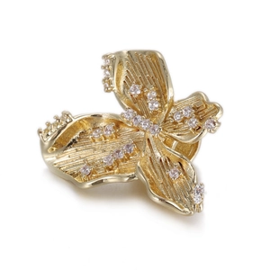 Macro shot of gold butterfly pendant with brushed metal texture and zircon inlay