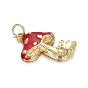 Close-up of a red mushroom pendant with 14k gold plating and drip oil craft details