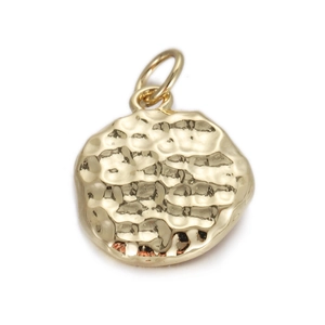 Detail of golden hammered circle pendant with irregular texture and round bail connector