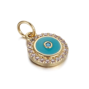 Macro detail of Evil Eye pendant with gold base, turquoise enamel, and white crystals