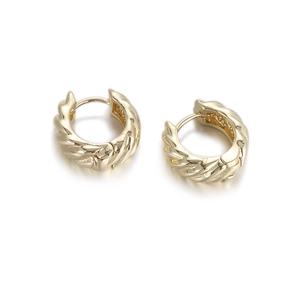 Macro detail of French retro style golden twisted hoop earrings with a glossy metal finish
