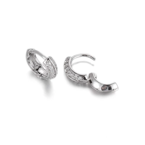 Macro shot of silver huggie hoop earrings showing open and closed clasp details