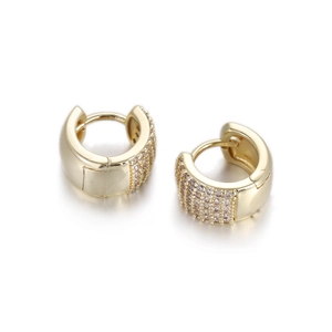 Close-up of gold huggie earrings with micro-pave cubic zirconia rows and metal shine