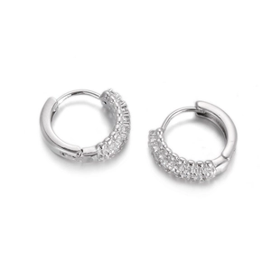Close-up of silver huggie earrings with rows of sparkling cubic zirconia stones