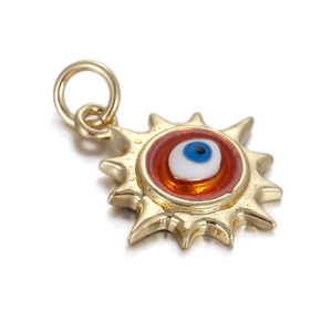 Close-up of golden sun-shaped Evil Eye pendant with orange resin and water droplets