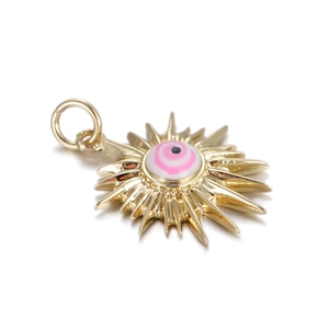Macro detail of golden sunburst evil eye pendant charm with pink and white enamel inlay