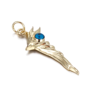 Macro detail of golden evil eye wing pendant with polished finish and blue eye bead