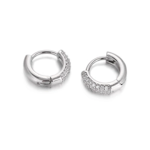 Close-up of silver hoop earrings with pave-set crystals and a polished hinged design