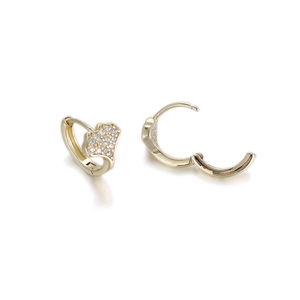 Macro detail of gold heart huggie earrings with cubic zirconia pavé and hinged closure