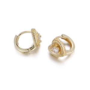 Detail of golden heart huggie earring with radiant texture and centered zircon stone