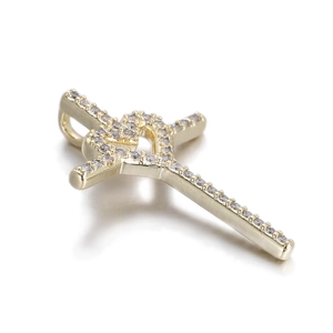 Macro view of a 14k gold plated cross pendant with zircon love heart inlay