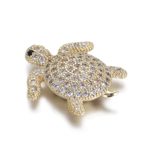 Detailed close-up of a 14k gold-plated turtle pendant with shimmering zircon crystals