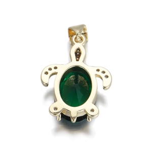 Macro detail of a 14k gold sea turtle pendant featuring a large green oval zircon stone