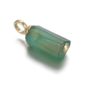 Macro view of a translucent green hexagonal stone pendant with a polished gold metal cap