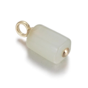 Macro shot of white translucent stone cylinder pendant with elegant gold metal fittings