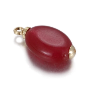 Macro detail of oval red agate pendant with smooth gold caps and bail for DIY jewelry