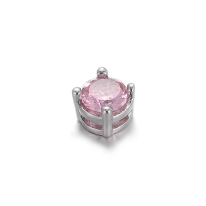 Macro d'une perle de zircon rose ronde sertie dans un support à quatre griffes argenté