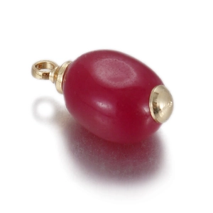 Macro shot of oval deep red gemstone pendant with golden metal loops for DIY jewelry
