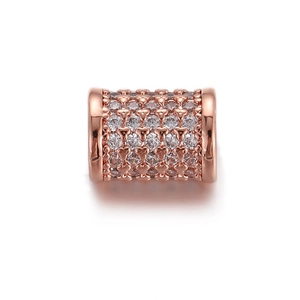 Dettaglio macro dello charm a cilindro in oro rosa con zirconi e cuori traforati