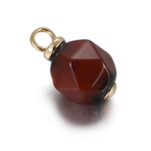 Macro shot of faceted dark red agate stone pendant with gold-plated metal caps and rings