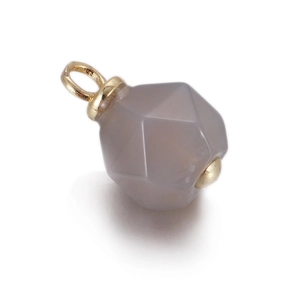 Macro detail of geometric faceted natural stone pendant with gold metal bail connector