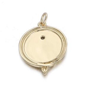 Detailweergave van een ronde gouden hanger met concentrische randtexturen en een gladde afwerking