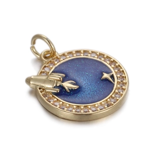 Detail van ronde gouden hanger met blauw raketontwerp en ingezette zirkoonsteentjes