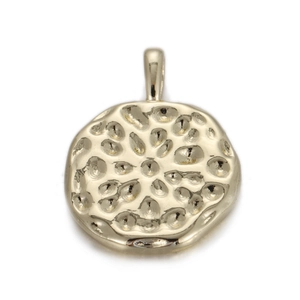 Macro detail van ronde gouden hanger met handgemaakte gehamerde textuur en ophangoog
