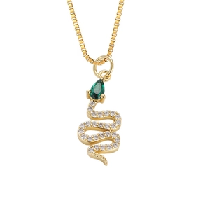 Macro van gouden slangenhanger met witte zirkoon en een peervormige groene steen