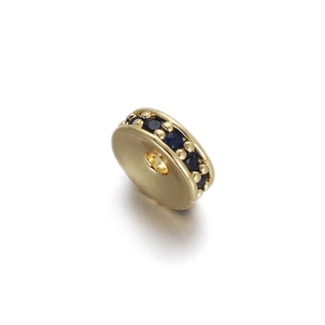 Makroaufnahme einer goldenen Radperle mit blauen Zirkoniasteinen für DIY-Schmuck
