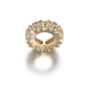 Macro detail of 14k gold-filled flower bead with pink zircon inlays for DIY jewelry