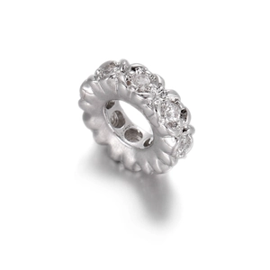 Macro detail of silver floral spacer bead with cubic zirconia and radial texture for DIY