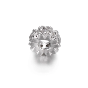 Macro detail of a 14k gold plated flower charm with a large clear zircon stone inlay