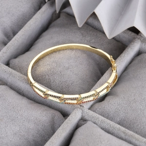 Détail d'un bracelet plaqué or avec deux rangées de zircons colorés et fermoir latéral