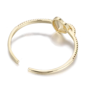 Détail d'un bracelet cœur doré avec des pierres précieuses colorées et fini poli