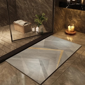 Detail of gray geometric bath mat with yellow V-line accent on dark marble floor