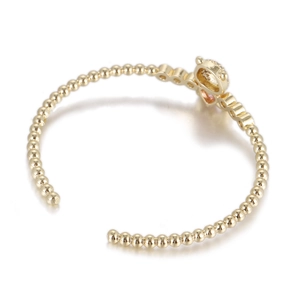 Détail du bracelet à perles dorées avec un charme de couronne et cœur rose