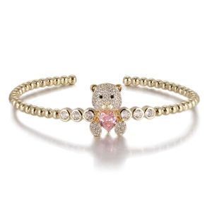 Détail macro du bracelet ours plaqué or 14k avec zircon coeur rose et pierres claires