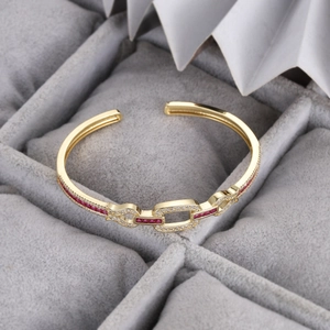 Détail du bracelet doré avec pavé de zircons blancs et une pierre précieuse rouge rubis
