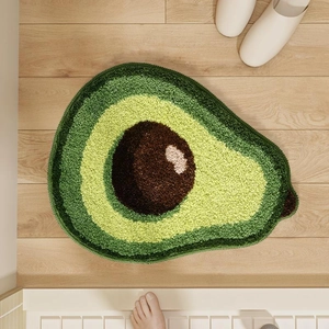 Détail d'un tapis touffeté en forme d'avocat avec texture douce sur sol en bois