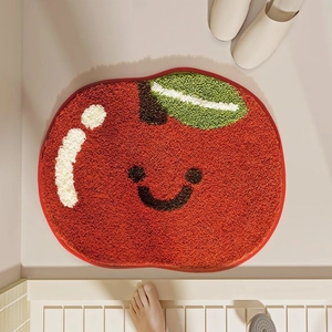 Détail d'un tapis en forme de pomme rouge avec visage souriant et texture douce en peluche