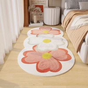 Detail view of floral runner rug with three pink and white tufted blossoms on wood floor
