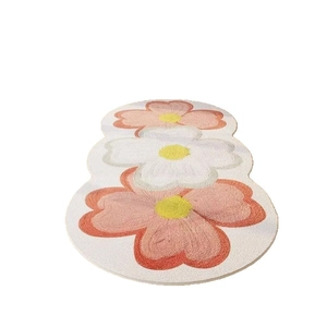Floral bedside rug with non-slip backing featuring three pink and white plush flowers
