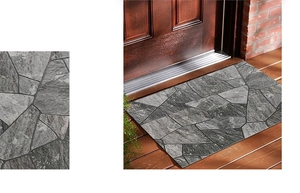 Détail du paillasson aux motifs de galets gris et son utilisation dans une entrée