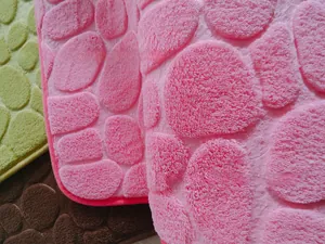 Close-up of 3D pebble embossed texture on thick coral fleece bathroom rugs in multiple colors
