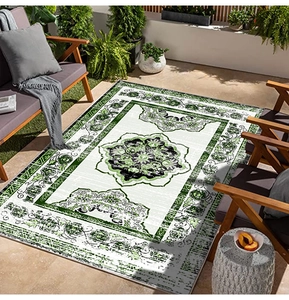Close-up of a rectangular Persian style outdoor rug with green mandala pattern on patio
