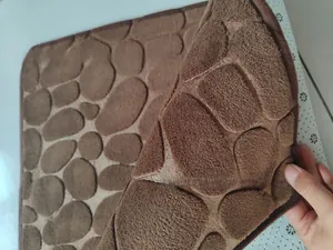 Detail of dark brown cobblestone bath mat showing plush texture and anti-slip backing