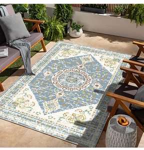 Detail of blue and white Persian outdoor rug with ethnic patterns on a modern patio